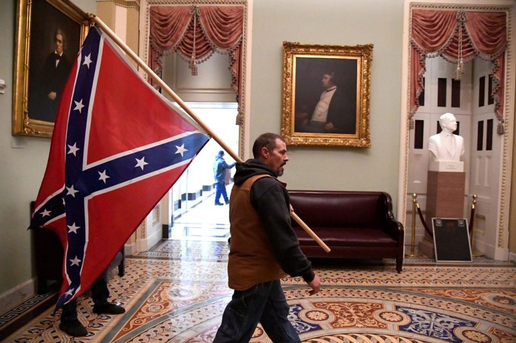 Um dos manifestantes entre os retratos de John C. Calhoun e Charles Sumner / Foto: Mike Theiler / Reuters