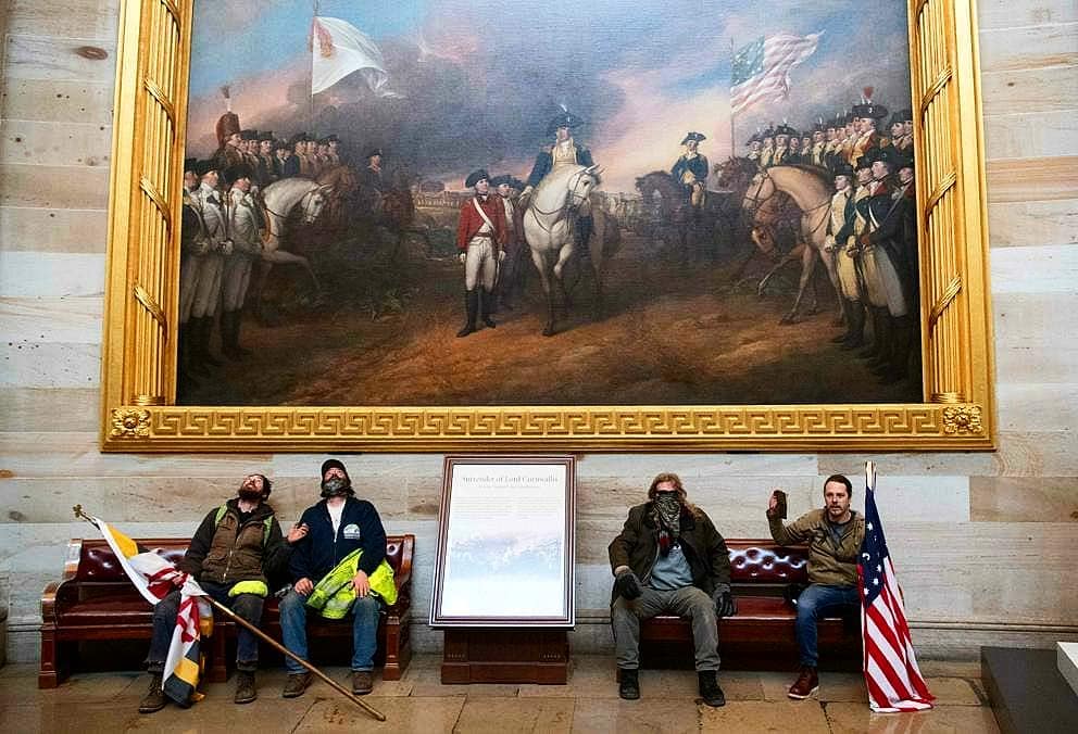 Manifestantes descansam debaixo da pintura que representa a independência norte-americana