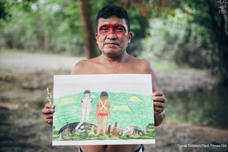 Joseca Yanomami segurando uma obra de sua autoria. (Reprodução)