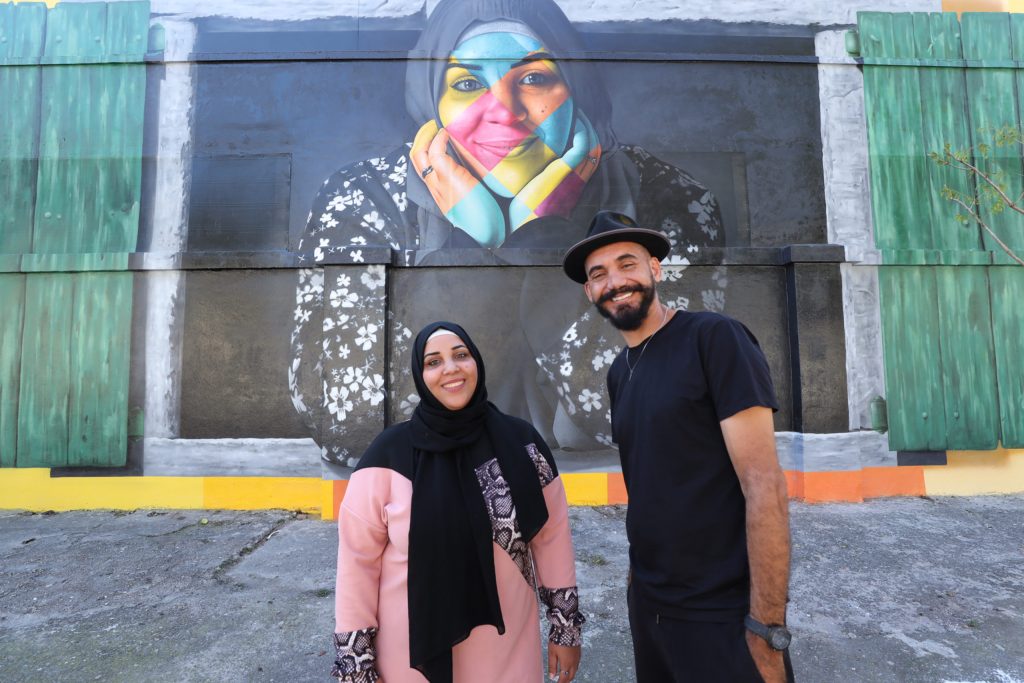 A palestina Noura e Eduardo Kobra na frente do mural “Janelas Abertas para o Mundo”